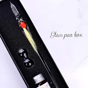 Macro detail of handmade glass dip pen set with jellyfish design and colored ink bottle