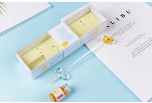 Detailed shot of a cartoon duck glass dip pen set with yellow ink and gift box packaging