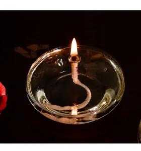 Macro detail of a lit smokeless glass candle holder showing a clear flame and oil texture