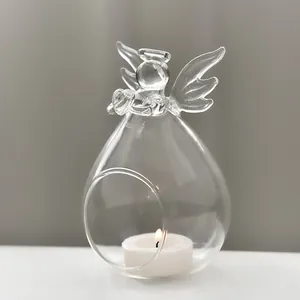 Detailed view of a clear glass angel candle holder with a glowing tealight inside
