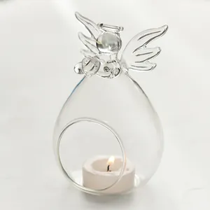 Close-up of elegant angel shaped clear glass candle holder with tea light candle