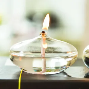 Elegant modern clear glass oil lamp with lit flame for cozy and minimalist home tabletop decor