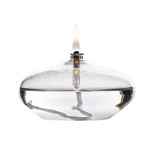 Elegant clear glass oil lamp with lit flame for modern home desktop interior decoration