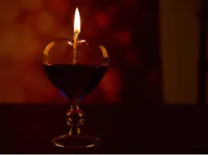 Lit heart-shaped glass oil lamp creating a warm romantic atmosphere for home decor