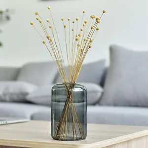 Modern minimalist smoke gray glass vase with dried yellow craspedia flowers for home decor