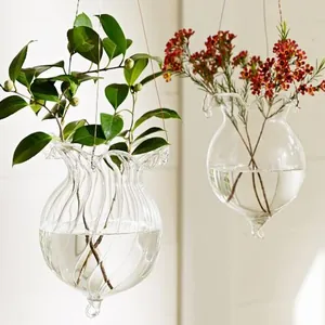 Detailed macro shot of hanging clear glass vases featuring elegant ruffled rim designs