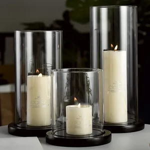 Elegant European style glass candle holder set with lit cream pillar candles on black bases