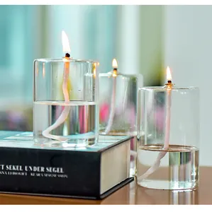 Detailed close-up of three burning transparent glass oil lamps on a decorative book