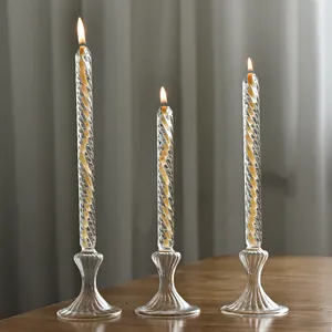 Tres elegantes lámparas de aceite de vidrio trenzado con llamas en una mesa de madera
