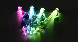 Close-up of luminous glass dip pens glowing in vibrant colors in the dark