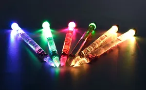 Close-up shot of six colorful luminous glass dip pens glowing vibrantly in the dark background
