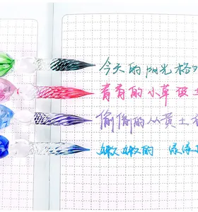 Macro detail of elegant colorful glass dip pen nibs writing on grid notebook