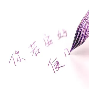 Macro view of a purple glass dip pen nib writing artistic calligraphy on white paper.