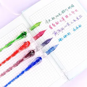 Premium set of five colorful handmade crystal glass dip pens displayed on a notebook