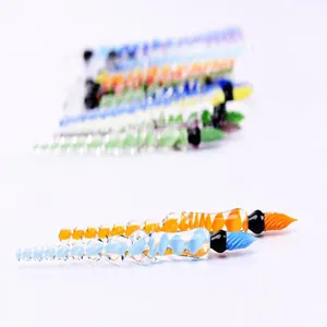 Macro detail of handmade spiral glass dip pens for ink testing in blue and orange colors