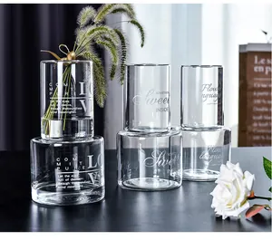 Close-up of transparent glass vases with elegant white letter printing for home decor