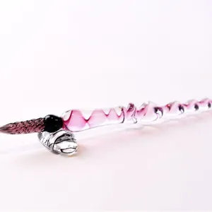 Elegant handmade spiral glass dip pen with ink testing nib and glass pen rest.