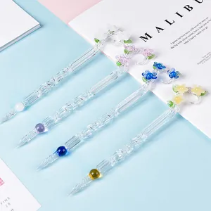 Elegant handmade floral glass dip pen set featuring decorative spiral nibs for calligraphy