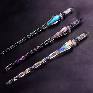 Close-up of three handmade glass dip pens with starry gradient glitter and spiral design.