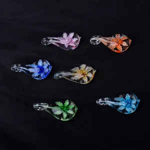 Vista detallada de reposaplumas de vidrio de colores con diseños florales internos