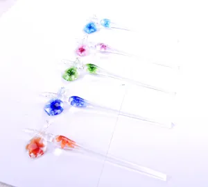 Detail view of handmade glass dip pens with intricate embedded colorful floral patterns
