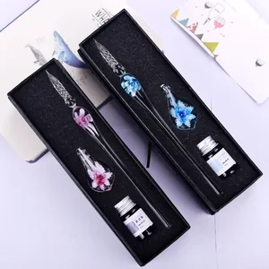 Macro view of two handmade glass dip pen sets with elegant blue and pink floral designs