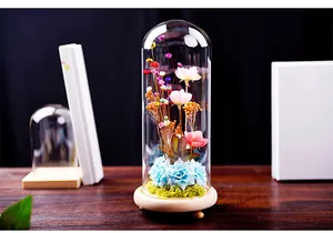 Elegant creative glass dome with colorful preserved flowers on a rustic wooden base.