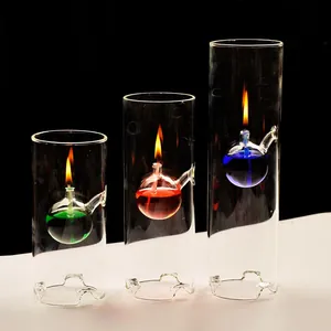 Detalle de lámparas de aceite de vidrio cilíndricas con combustible de colores y llama