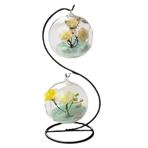 Double hanging glass terrarium vases on S-shaped metal stand with artificial flowers