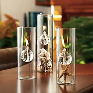 A set of three cylindrical clear glass oil lamps featuring decorative seashells and starfish