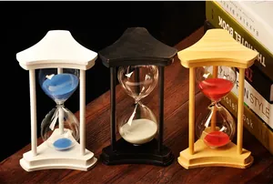 Three wooden frame hourglasses with blue white and red sand on a dark table.
