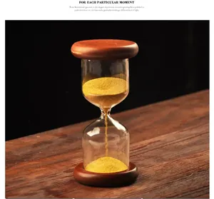Detailed view of a glass hourglass with golden sand and dark wooden bases.