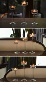 Group of three slender glass candle holders of varying heights with warm glowing flames