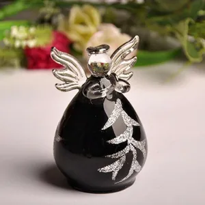 Detailed view of a black glass angel figurine with silver glitter tree pattern