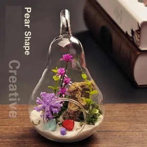 Detail view of a pear-shaped clear glass vase terrarium with artificial micro-landscape