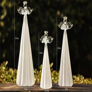 Dimensioni dettagliate di tre figurine di angeli in vetro smerigliato su superficie di legno