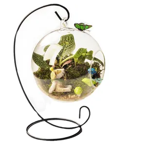 Round hanging glass terrarium with micro landscape on a black metal stand