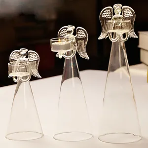 Dettaglio che mostra tre diverse dimensioni di figurine di angelo in vetro con candele.