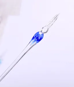 Detail view of a handmade glass dip pen with blue flower inlay and twisted nib.