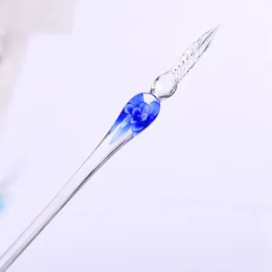 Elegant handmade glass dip pen with blue floral inlay for calligraphy and creative writing.
