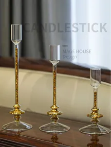 Elegant set of three clear glass candlesticks with golden glitter quicksand effect inside
