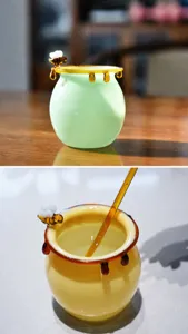 Close-up of a glass honey jar featuring a 3D bee decoration and a smooth amber glass rim