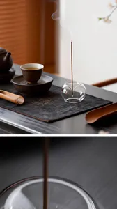 Macro view of transparent glass incense holder with burning stick in Zen tea setting