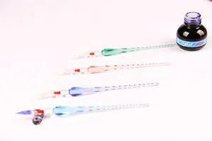 Collection of four handcrafted spiral glass dip pens in various colors with dark blue ink