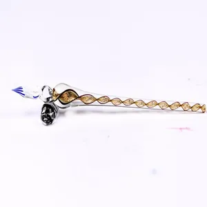 Detailed macro shot of a glass dip pen with golden spiral interior and blue tip.