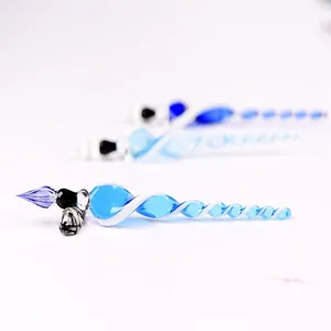 Close-up of a handmade spiral glass dip pen with elegant blue and white twists