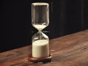 Detailed view of a vintage glass hourglass with white sand on a wooden base and table
