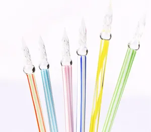 Detail view of handmade glass dip pens with colorful spiral bodies and twisted glass nibs