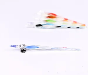 Detailed macro view of a blue spiral glass dip pen resting on a clear glass stand