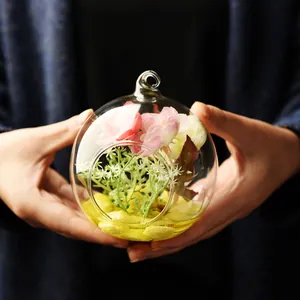Handheld transparent round glass terrarium with artificial flowers for home decoration